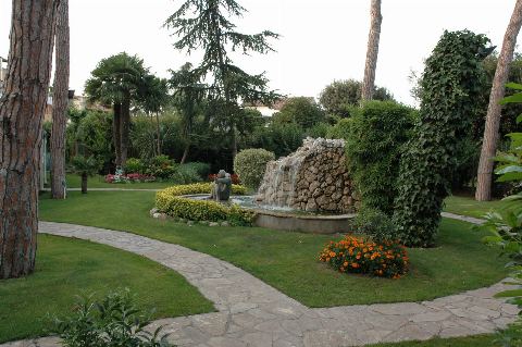 Camí de pedra pel jardí cap a la font amb cascada
